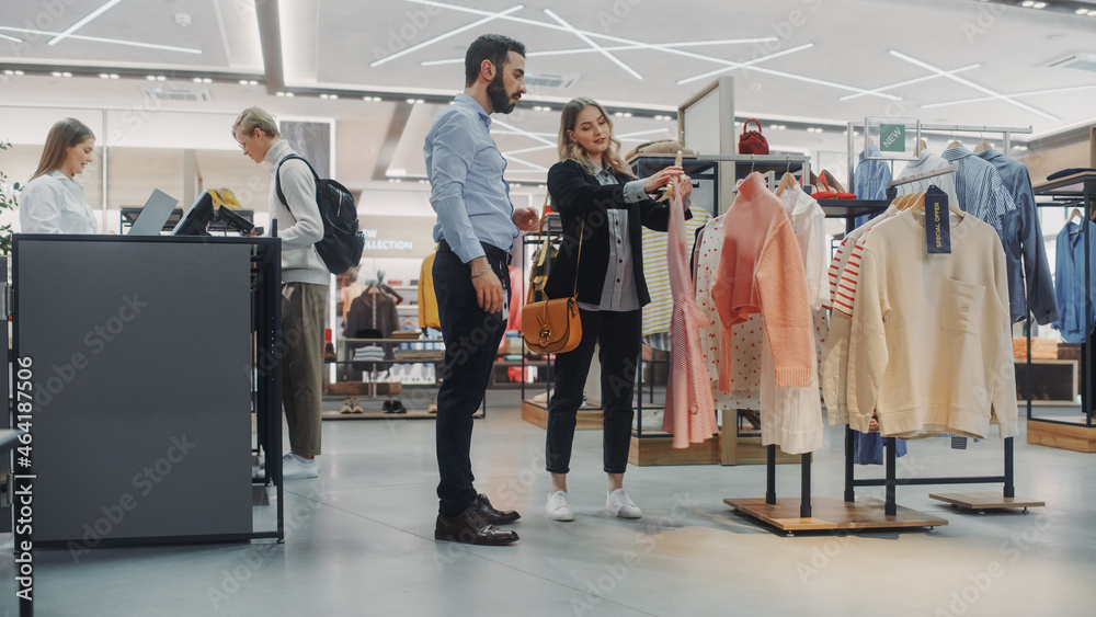 Beautiful Female Customer Shopping in Clothing Store, Retail Sales Associate Helps with Advice. Dive