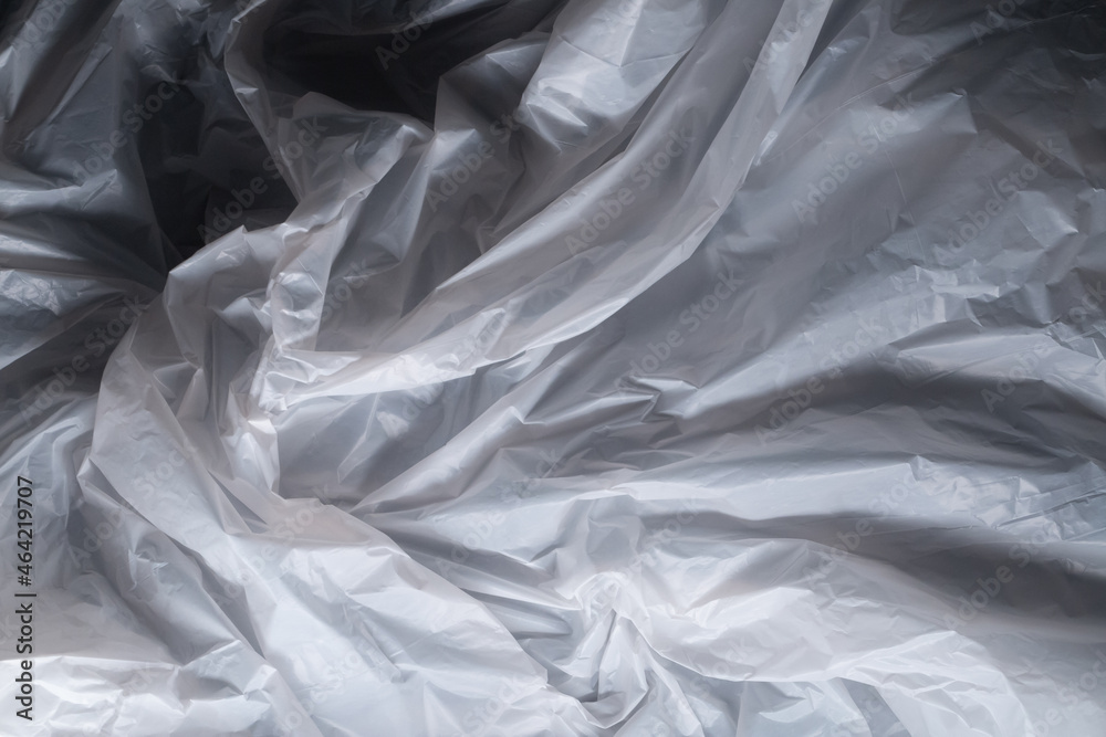 Reflecting light and shadow on creases and folds in scrunched thin white sheet of fabric or paper