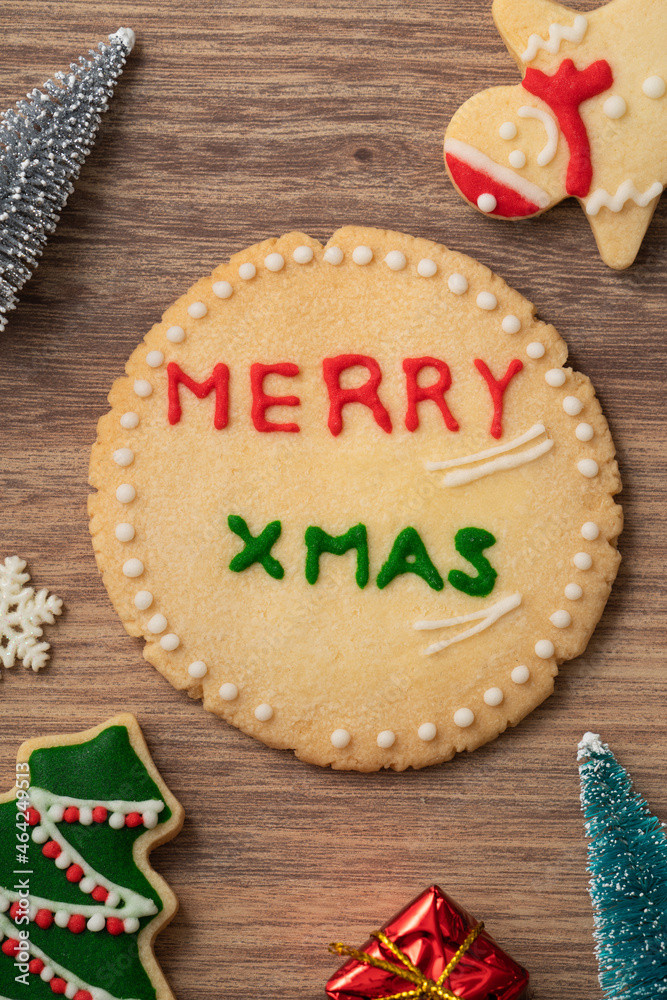 Decorated Christmas gingerbread cookies with decorations on wooden table background.