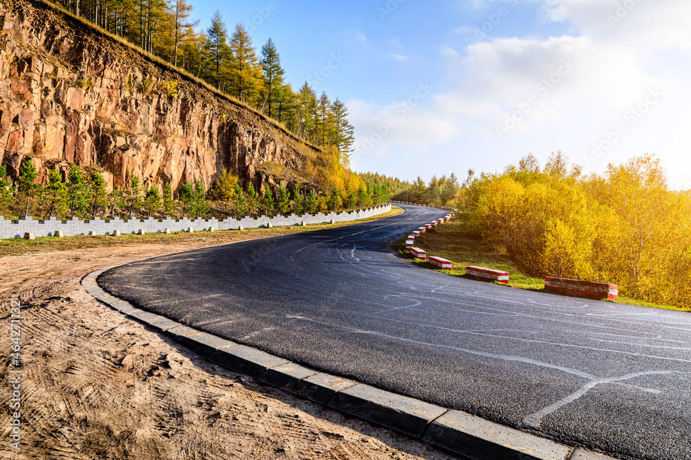 Empty asphalt road and autumn trees landscape.Road and forest with mountain background.