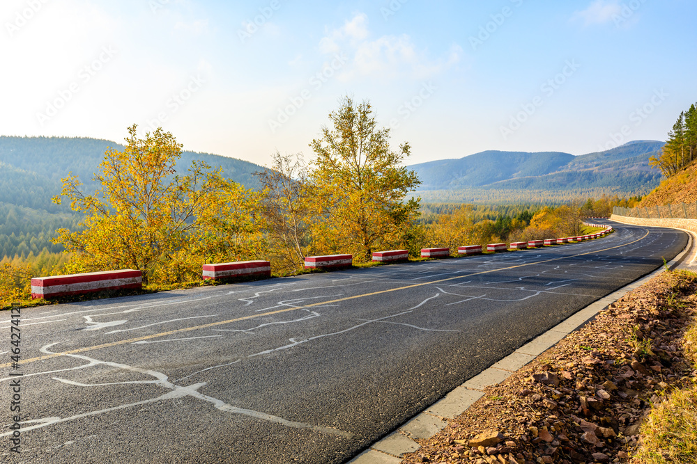 Empty asphalt road and autumn trees landscape.Road and forest with mountain background.