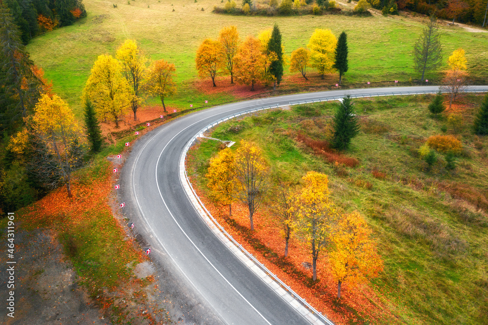 秋天日落时蜿蜒的道路和五颜六色的树木的鸟瞰图。宇中山路的俯视图