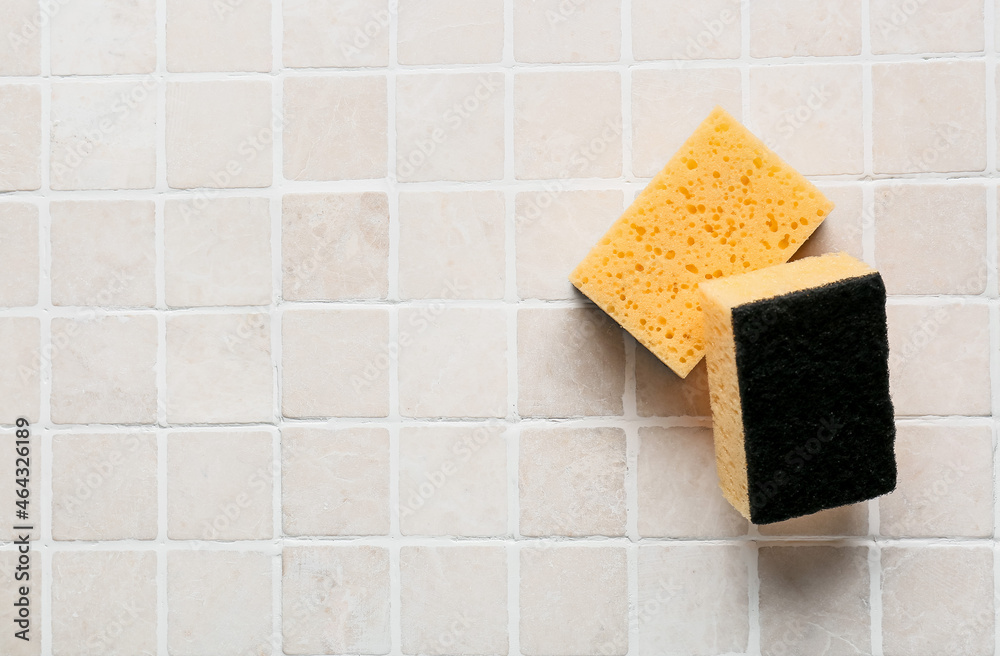 Yellow cleaning sponges on tile background