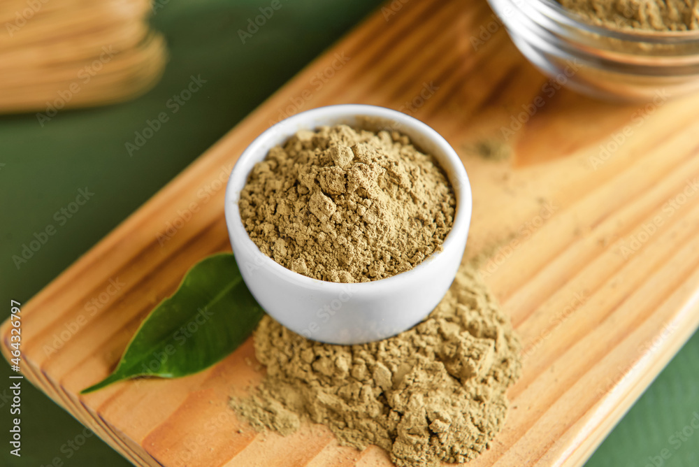 Bowl with hojicha powder on green wooden background