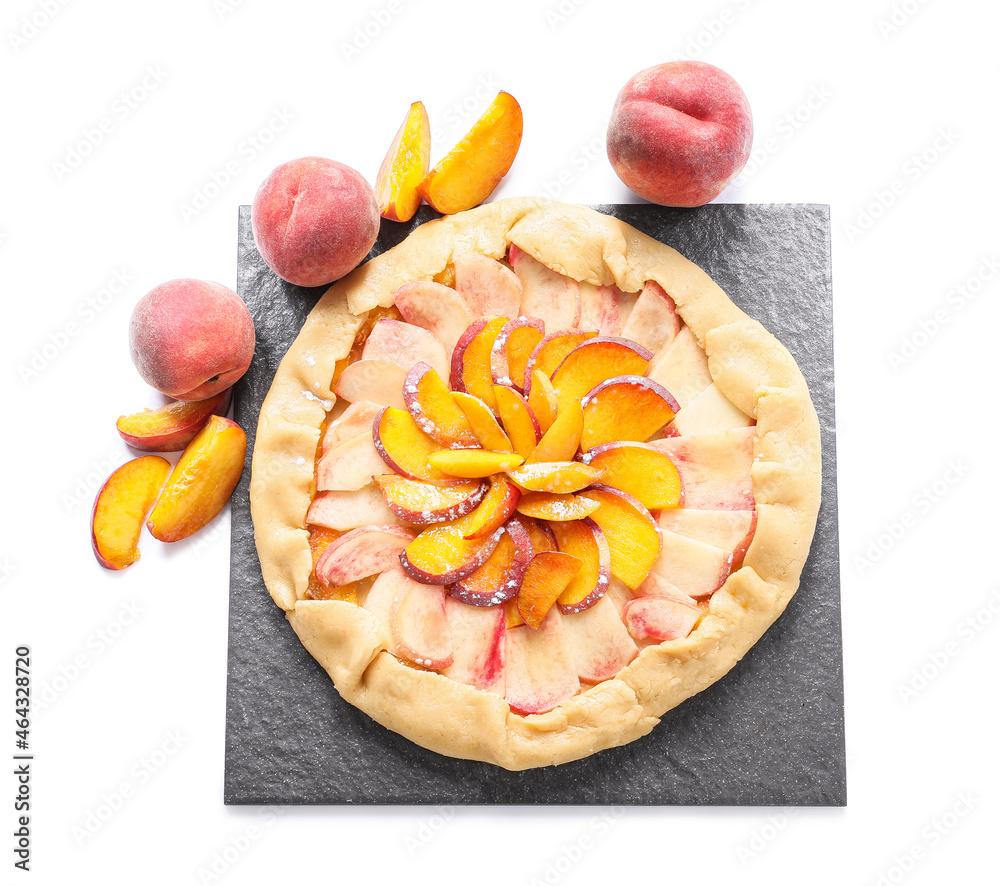 Slate plate with raw peach galette on white background