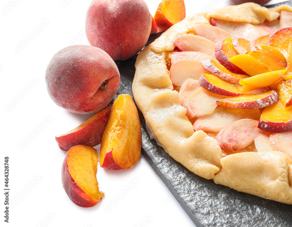 Slate plate with raw peach galette on white background, closeup