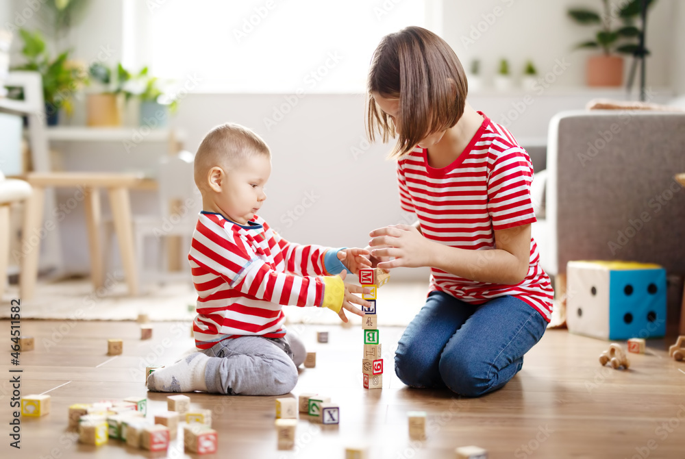 Sister and brother playing with toys together on the floor indoors.