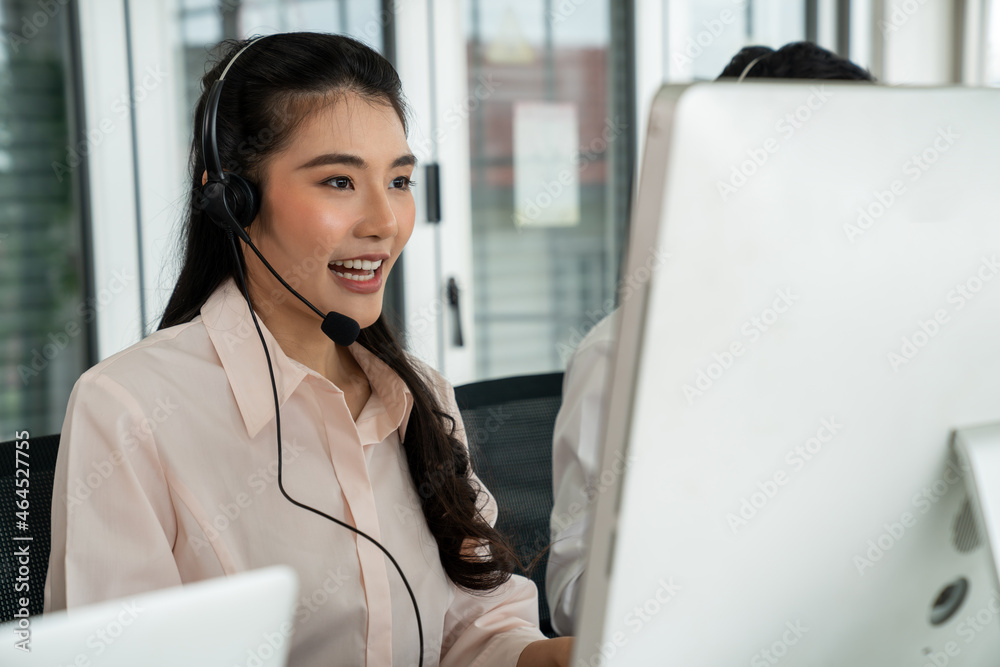 Businesswoman wearing headset working actively in office . Call center, telemarketing, customer supp