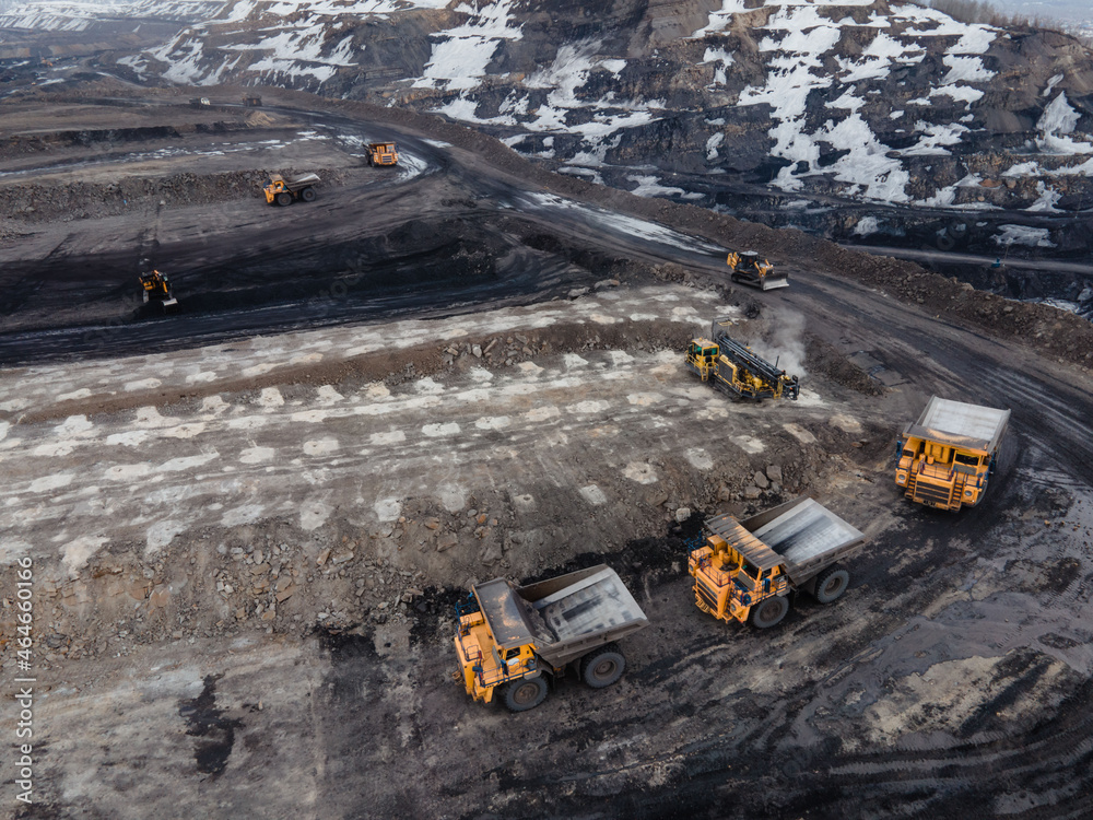 Industrial zone. Open pit, mining industry. a bright-colored excavator loads the earth into a truck,