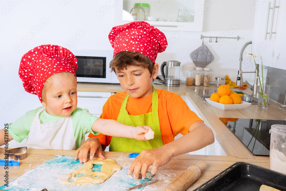 Boys cutting dough out cookies in heart shapes