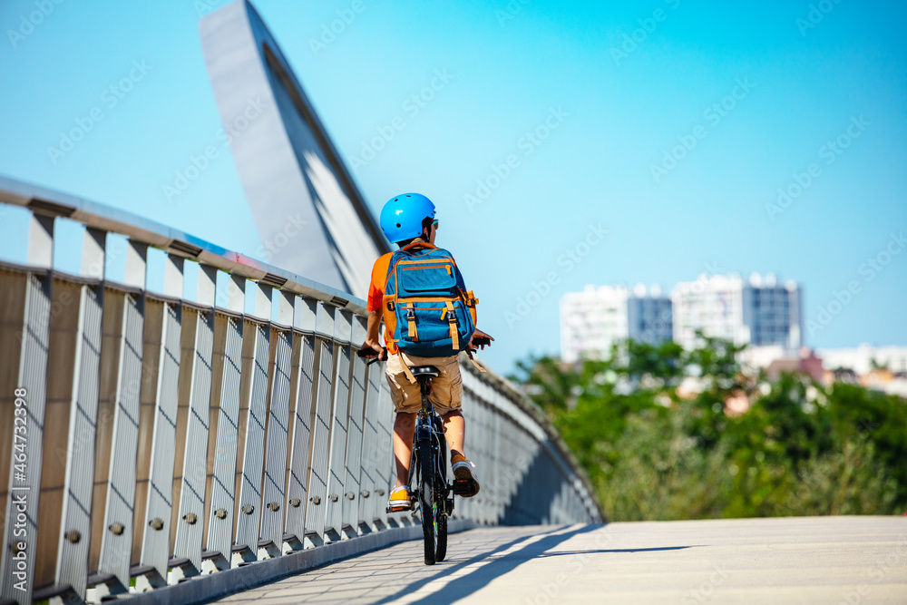 Confident boy cycle to school on bike in city