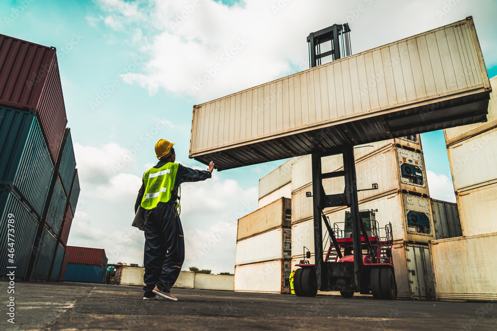 Young African American woman worker at overseas shipping container yard . Logistics supply chain man