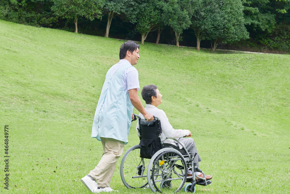 高齢者の車椅子を押す介護士