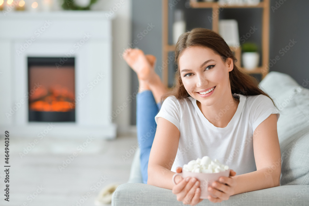 Beautiful young woman with cup of hot cacao drink at home