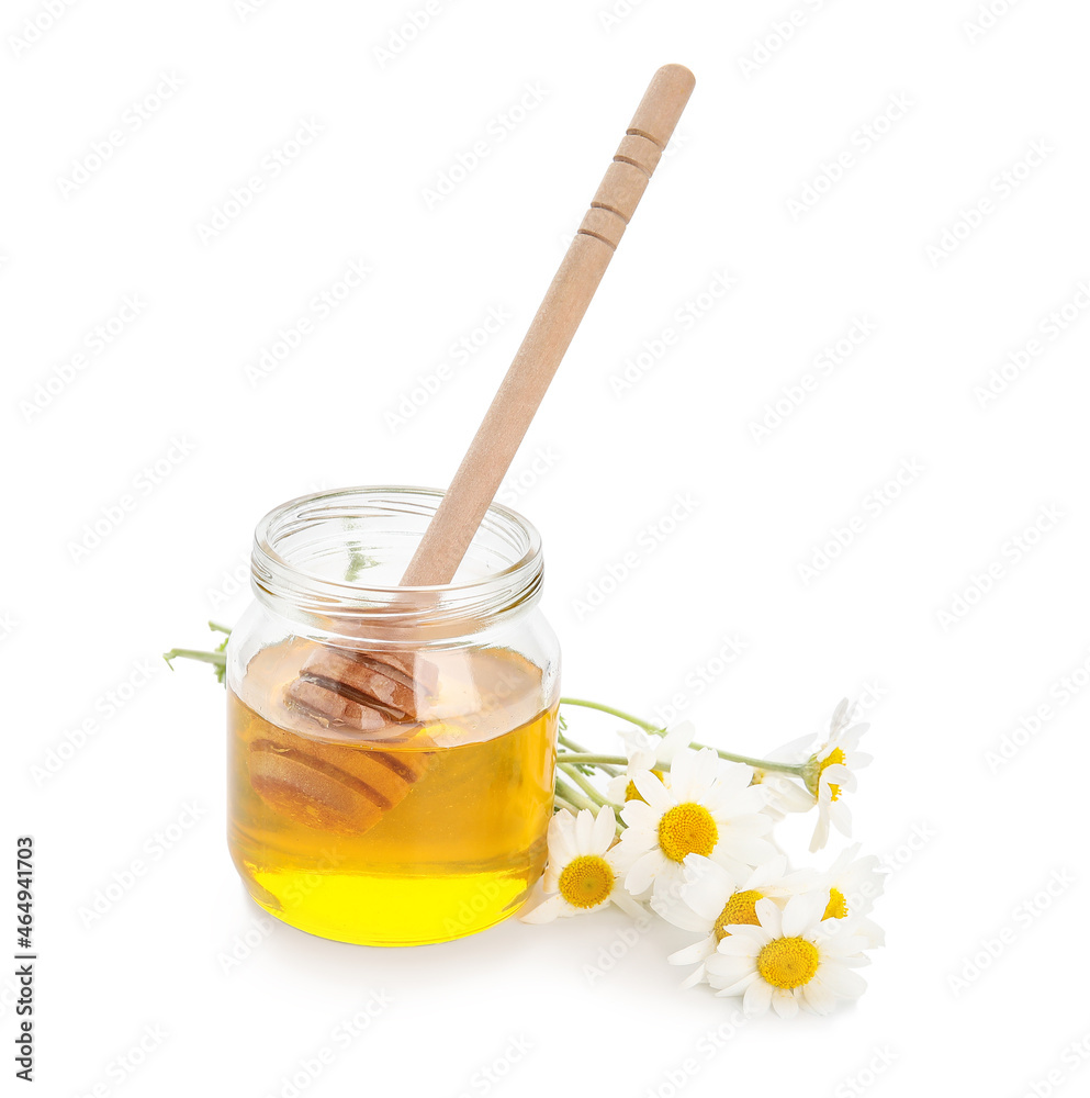 Jar of sweet honey and chamomile flowers on white background