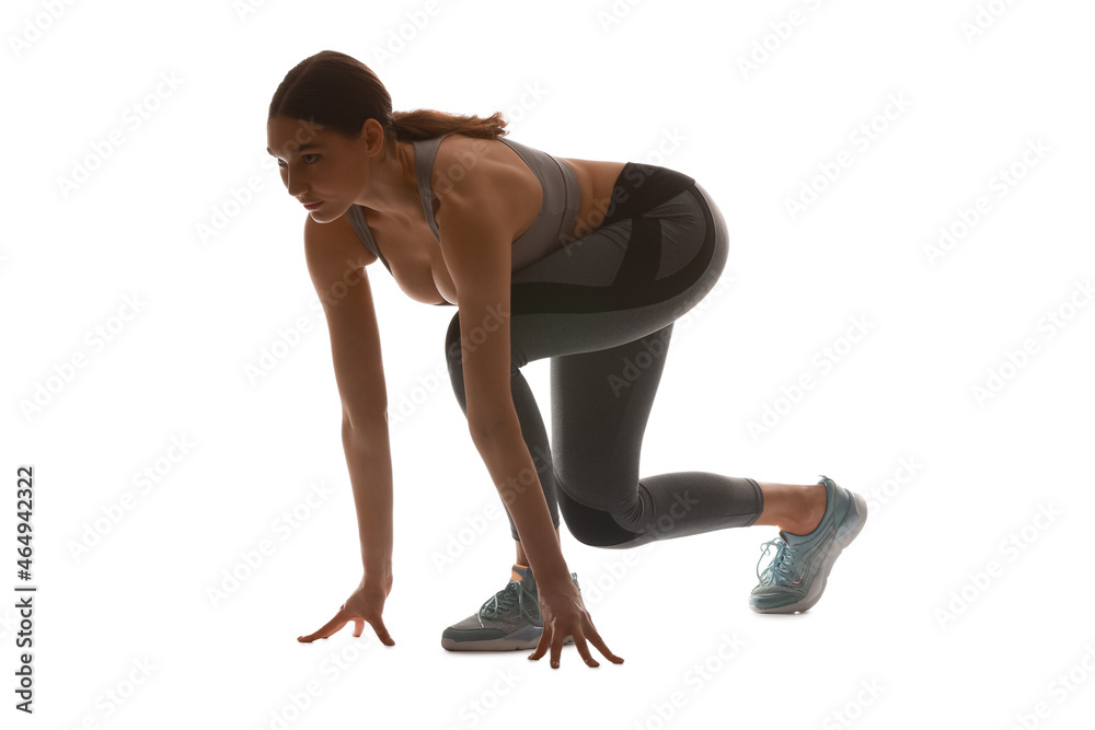 Silhouette of sporty young woman in crouch start position on white background