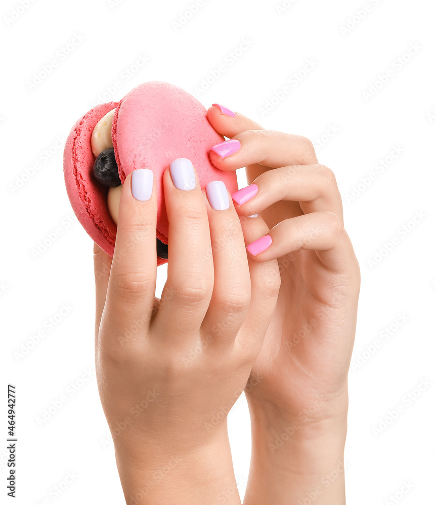 Woman with trendy manicure holding macaron on white background, closeup