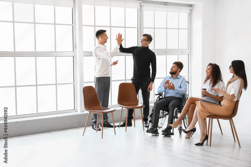 Male colleagues giving each other high-five during meeting in office