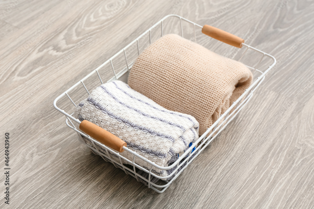 Basket with clean clothes on grey wooden background