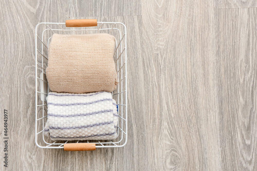 Basket with clean clothes on grey wooden background