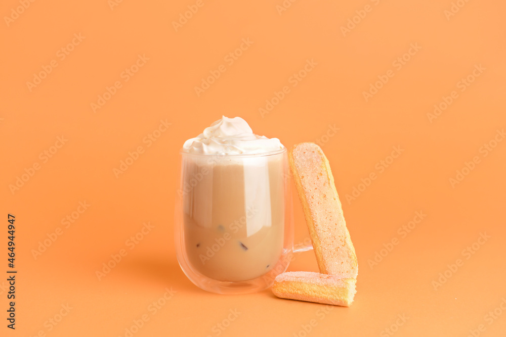 Glass of tasty Tiramisu Latte on orange background