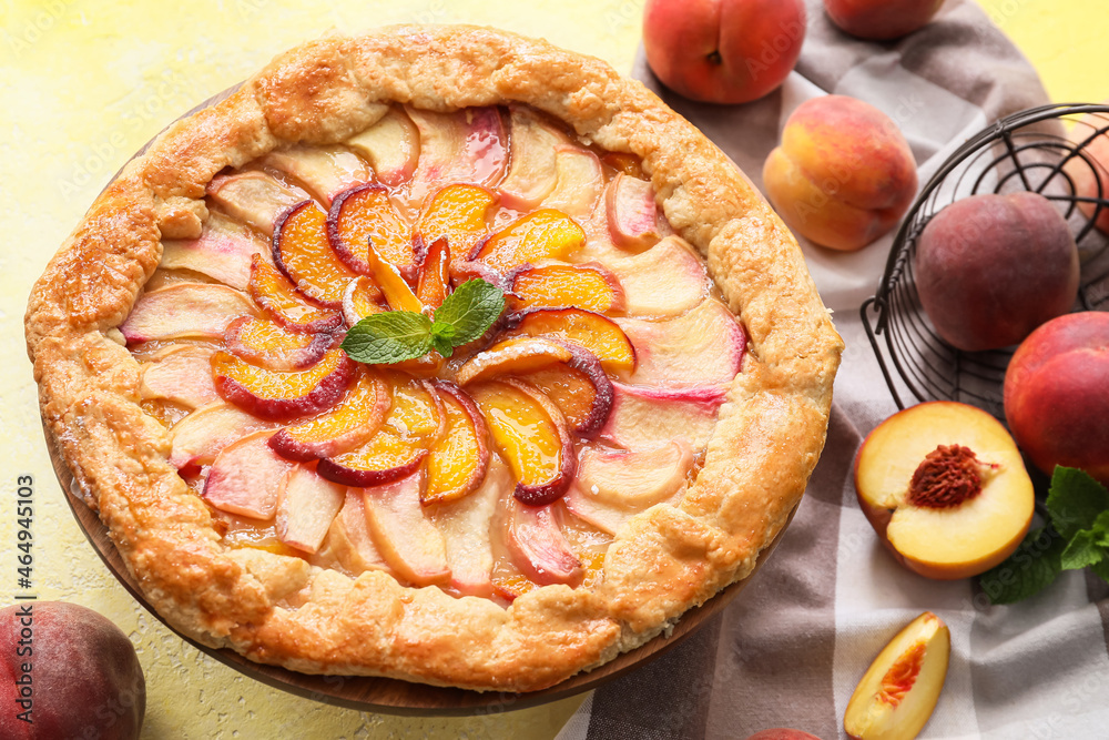 Plate with tasty peach galette on color background, closeup