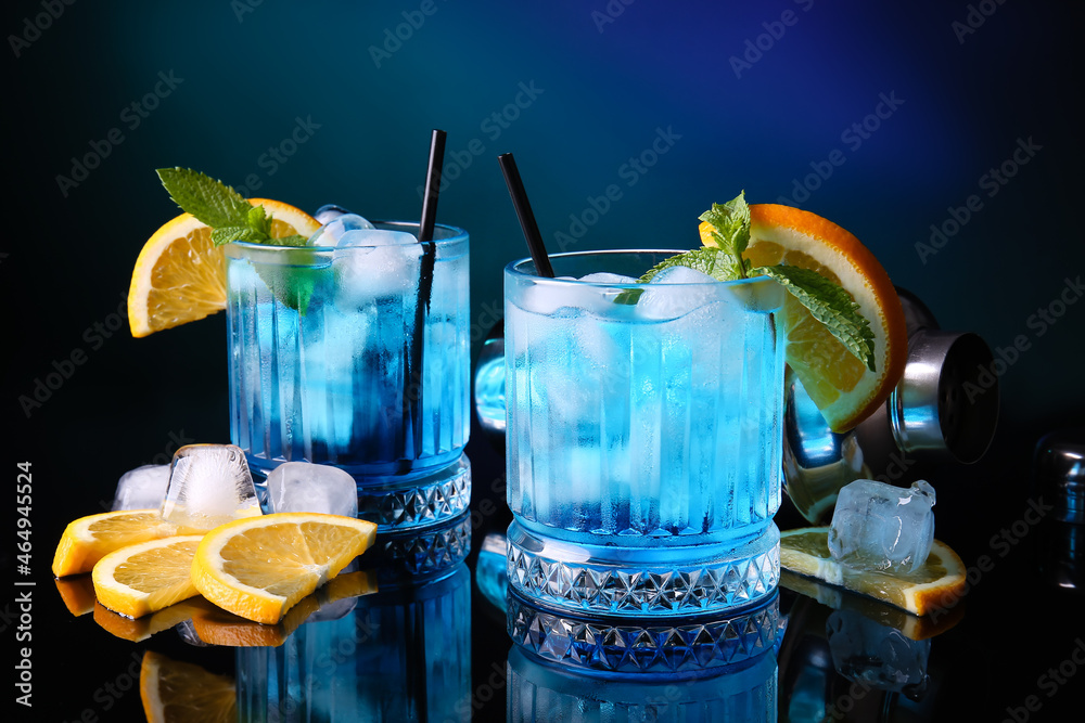 Glasses of Blue Lagoon cocktail on dark color background