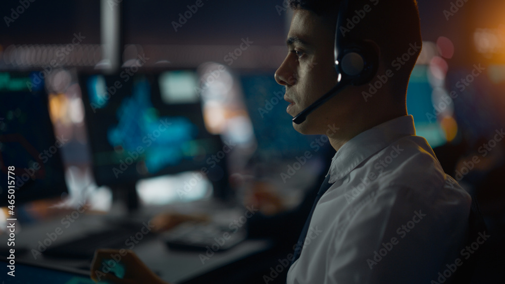 Male Air Traffic Controller with Headset Talk on a Call in Airport Tower. Office Room is Full of Des