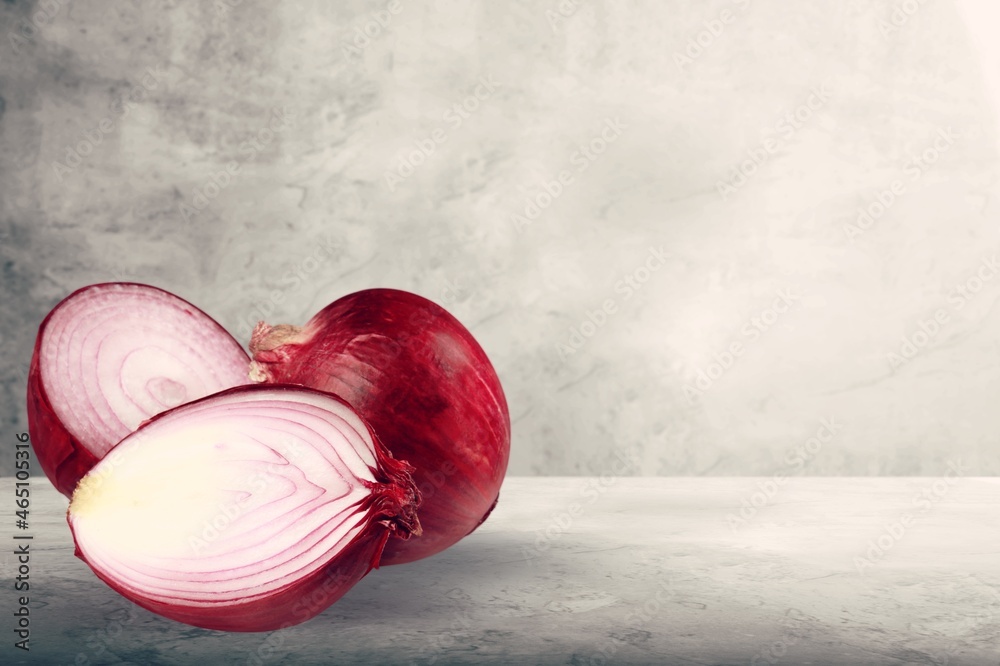 Red whole and sliced onion on the desk