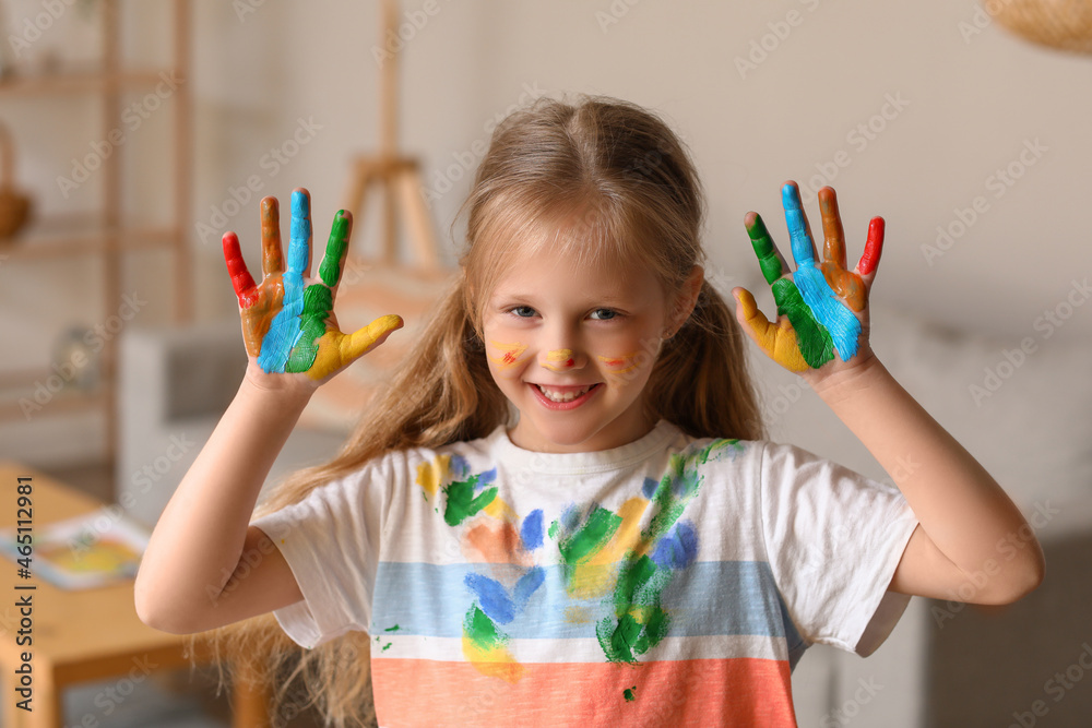 Little girl with her palms in paint at home