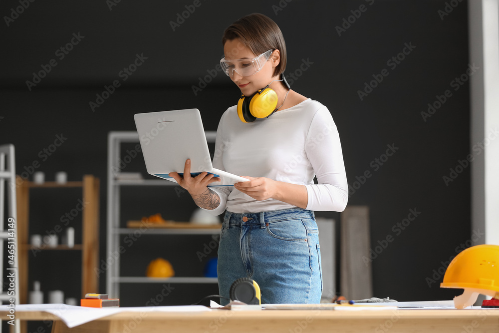 女建筑工人在办公室使用笔记本电脑