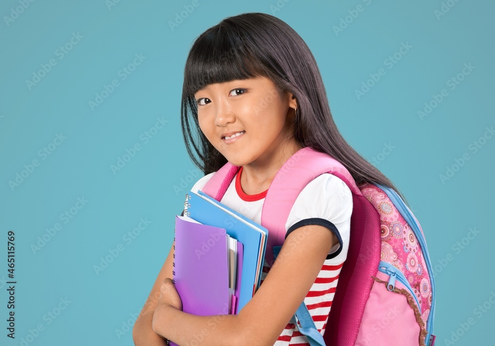 Smiling little kid with backpack hold books