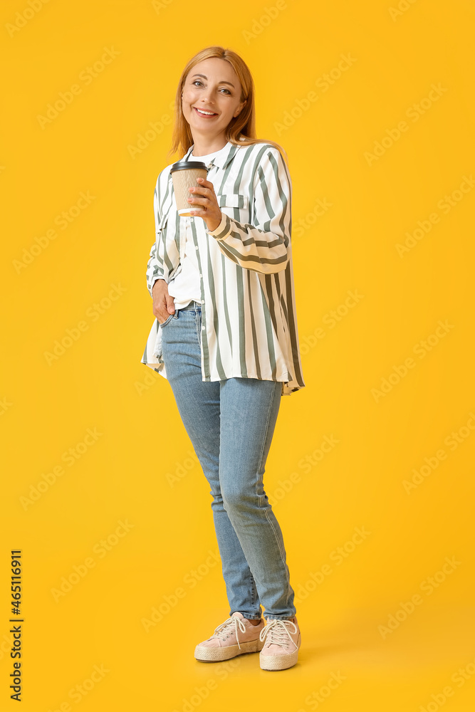 Beautiful mature woman with cup of coffee on color background