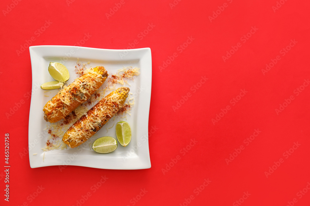 Plate with delicious Elote Mexican Street Corn on red background