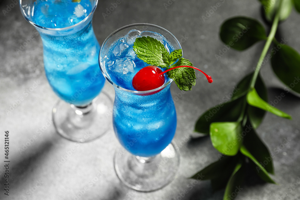 Glasses of Blue Lagoon cocktail on dark background, closeup