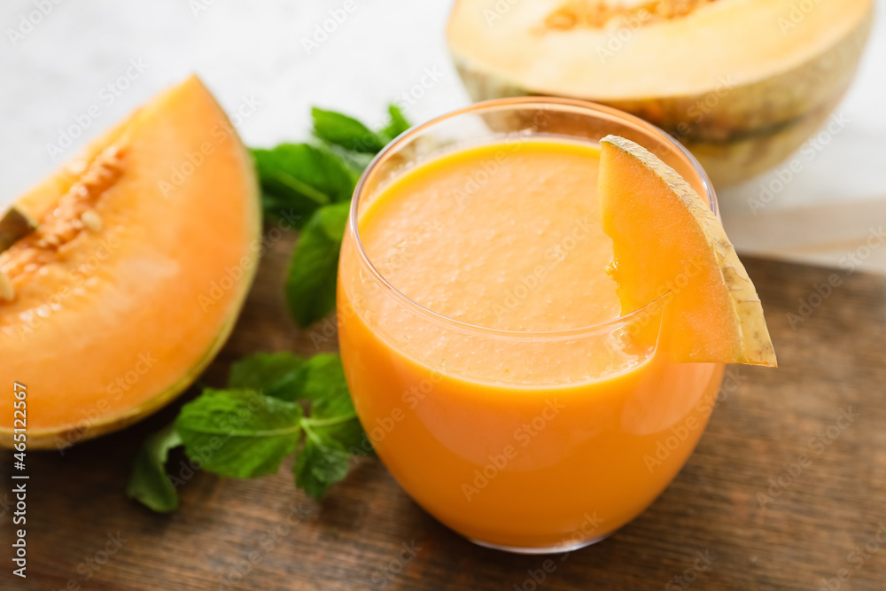 Glass of tasty melon milkshake on table, closeup