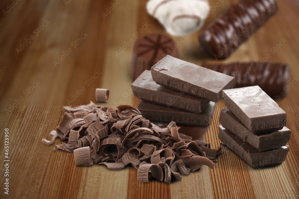 Composition of bars and pieces of different milk and dark chocolate on the desk