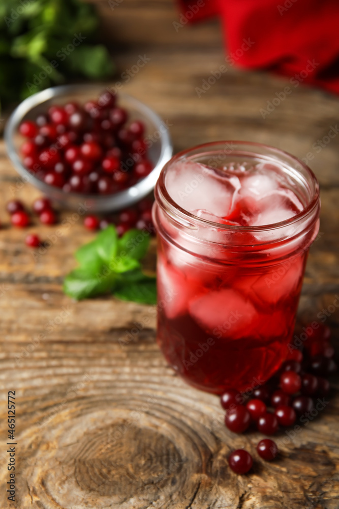 Glass with healthy cranberry juice on wooden background