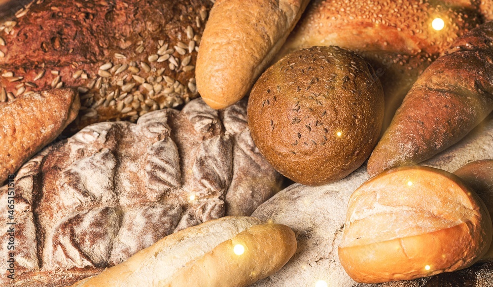 Fresh loaves of bread with wheat and gluten on a table