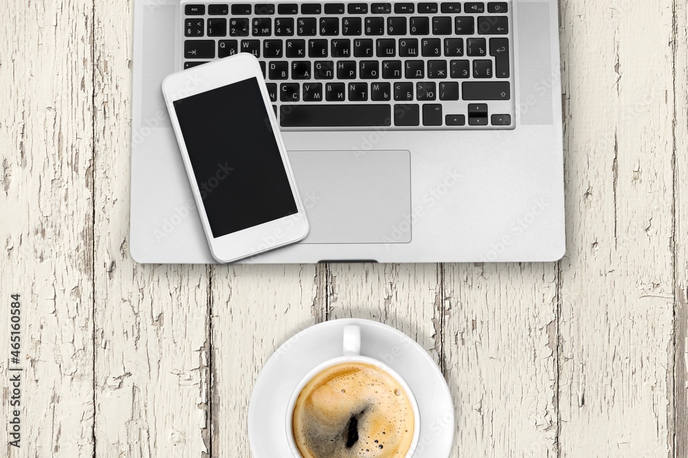 Modern office desk with a smartphone, laptop