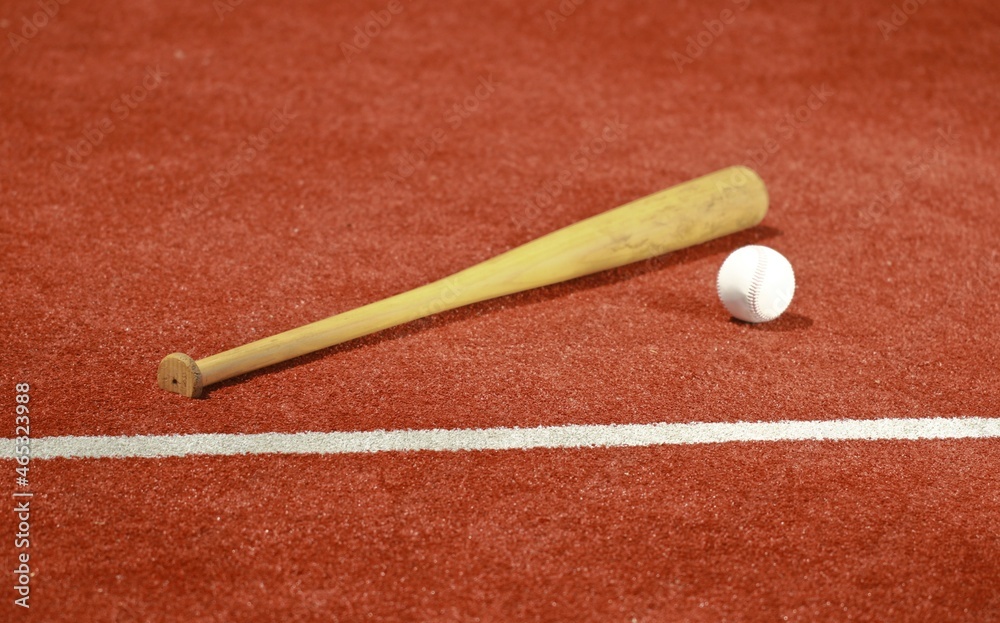 Baseball and baseball bat on turf