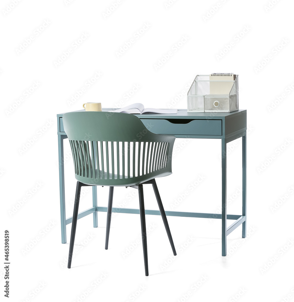 Modern table with cup, opened magazine, organizer and chair on white background