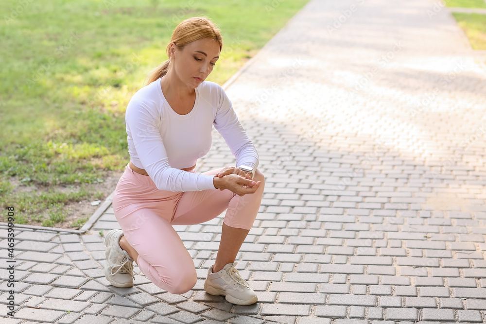 Female runner checking pulse outdoors