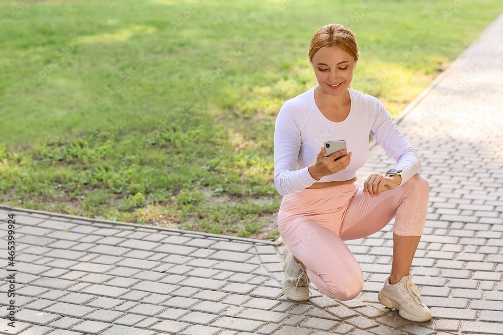 Female runner checking pulse outdoors