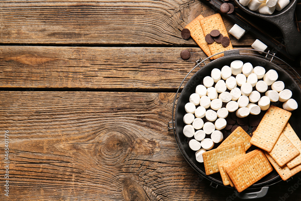 Frying pan with uncooked Smores dip on wooden background