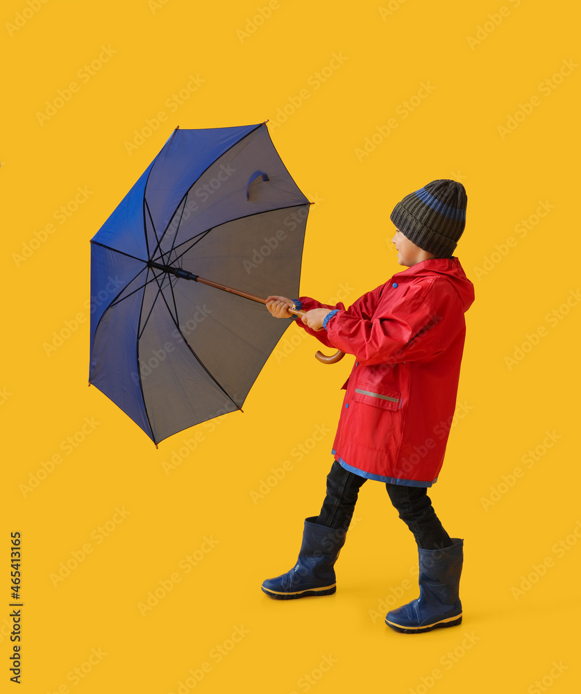 小男孩穿着雨衣，彩色背景带雨伞