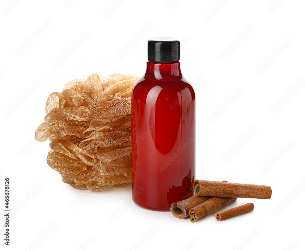 Bottle of shower gel, sponge and cinnamon on white background