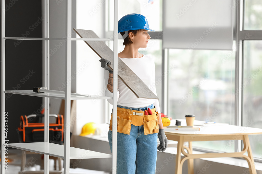 Female construction worker with wooden plank in room