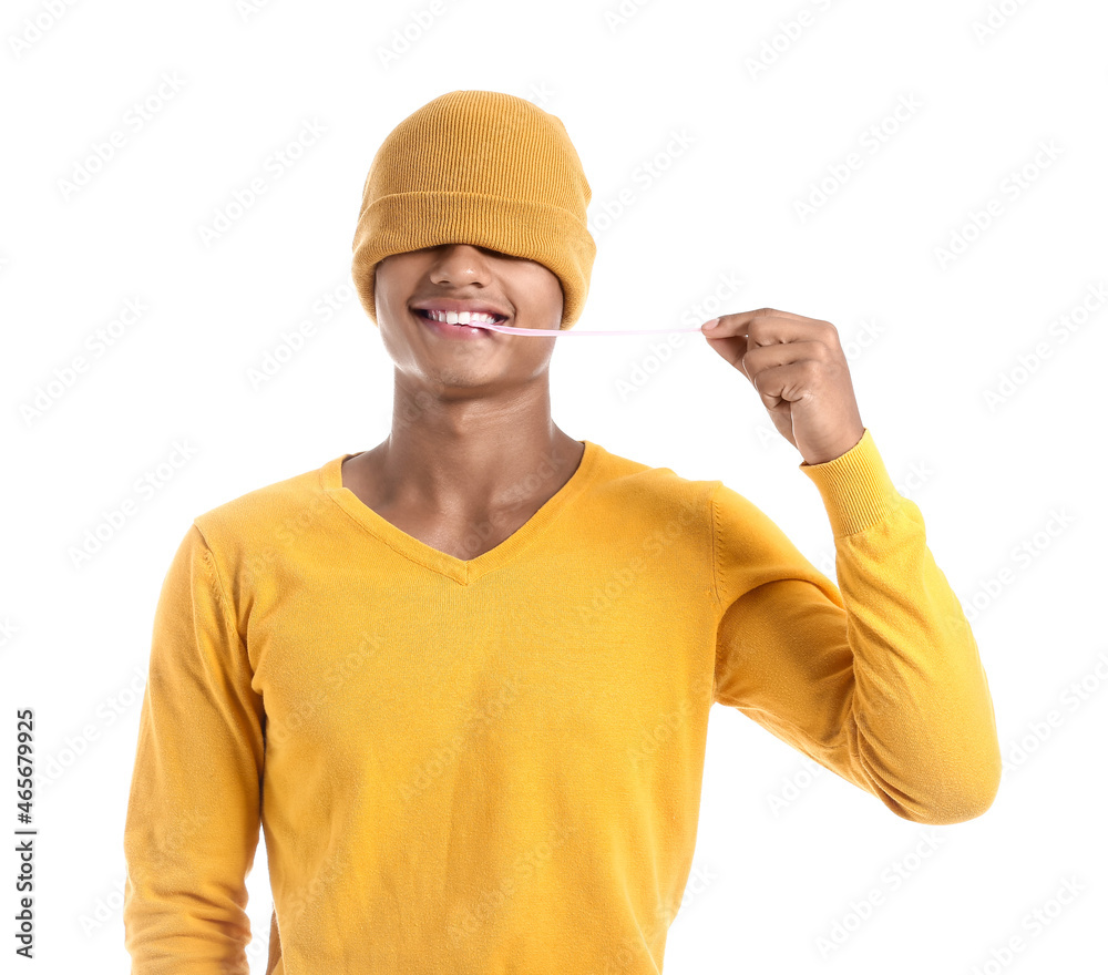 Funny African-American guy with chewing gum on white background