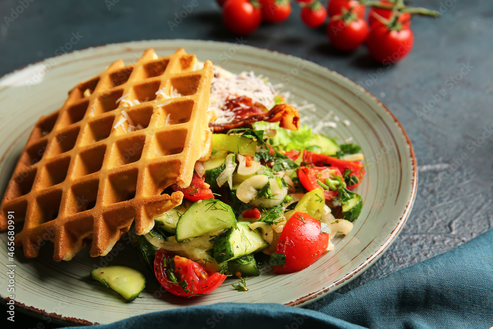 Plate with tasty Belgian waffles and vegetables on dark background, closeup